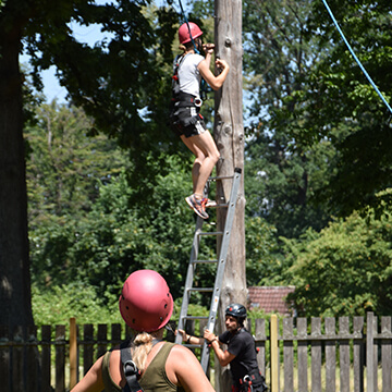 Eine Person klettert über ein Seil