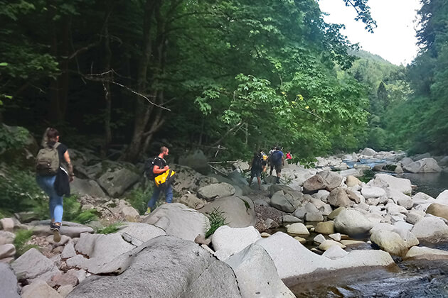 Menschen wandern an einem Fluss entlang Menschen wandern an einem Fluss entlang